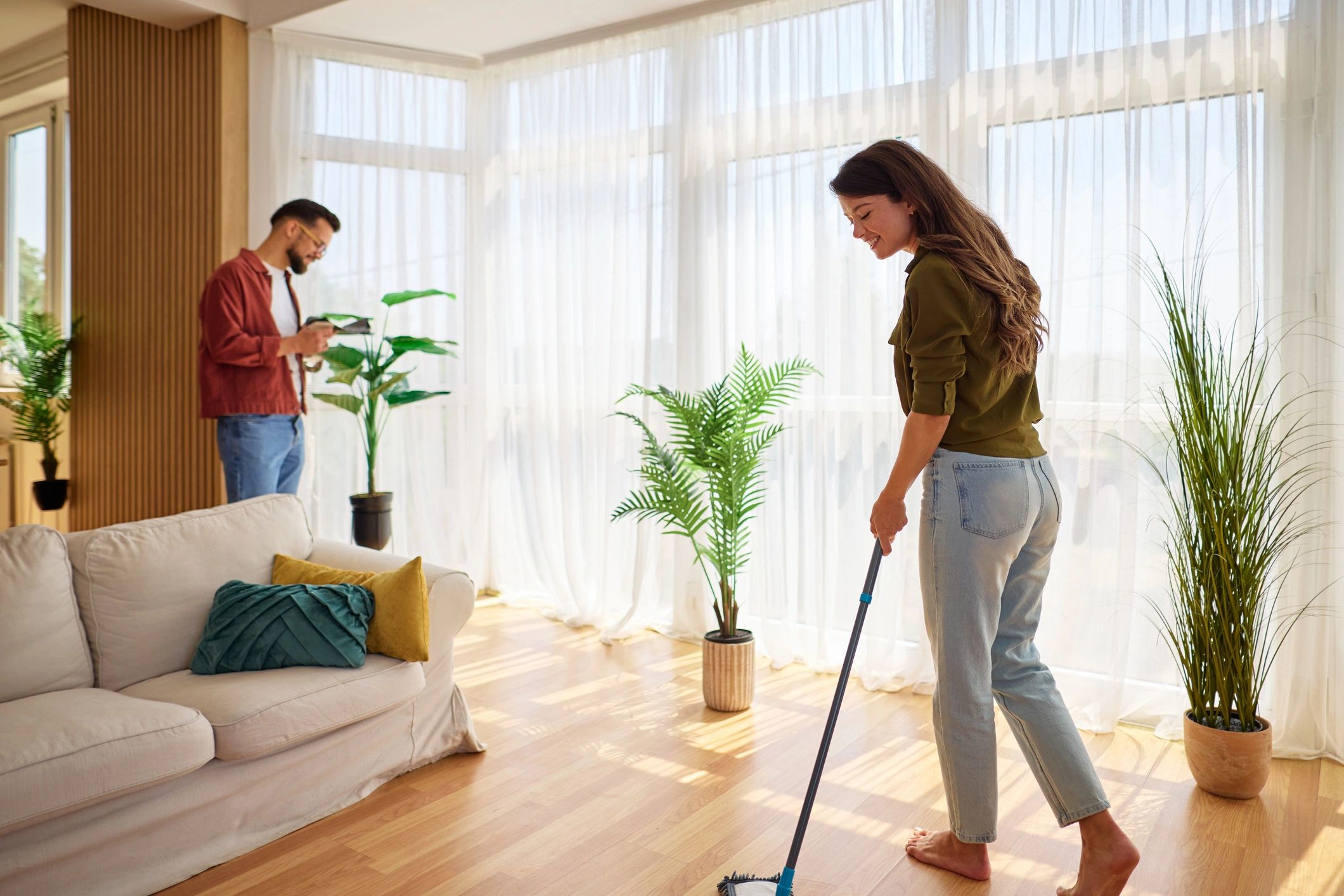 Couple doing housework in a clean living room